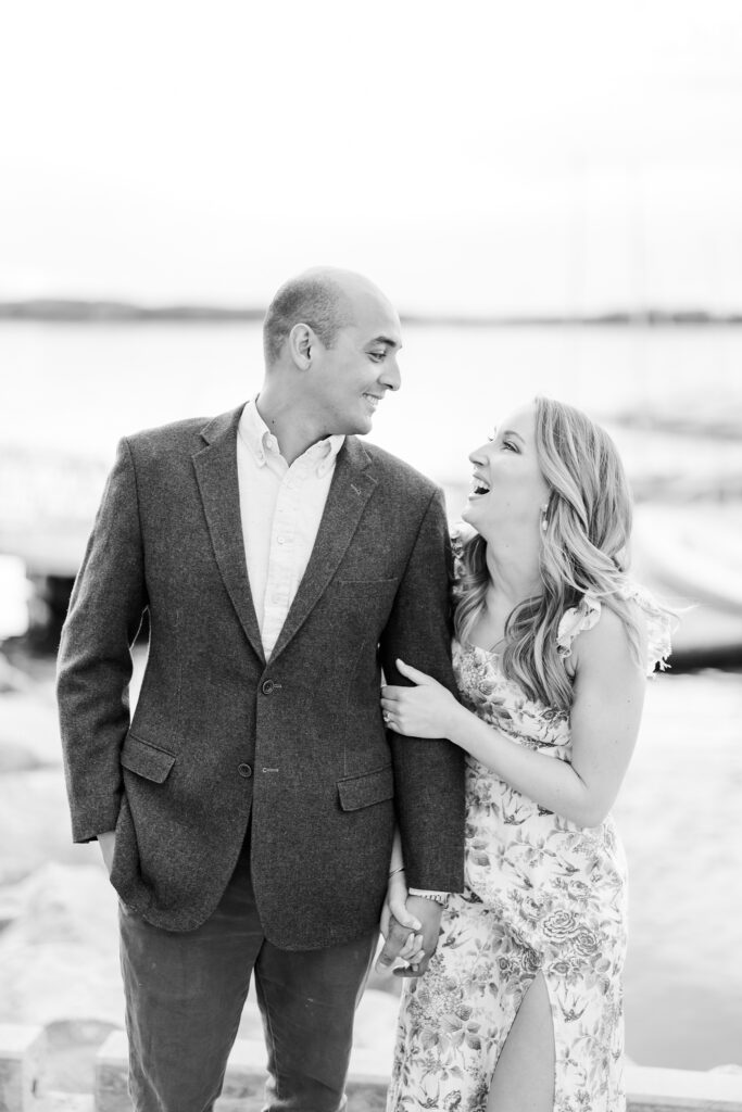 couple laughing at each other during a lake front engagement