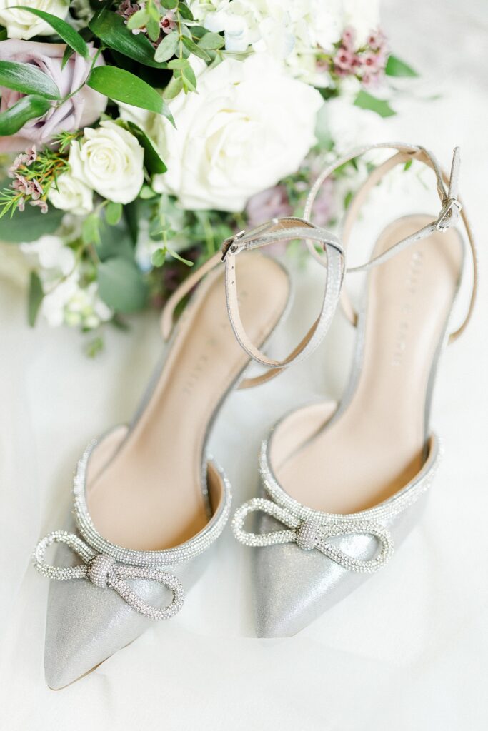 silver shoes next to a bouquet of flowers