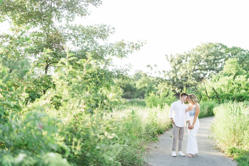 couple standing on paved pathway surrounded by greenery