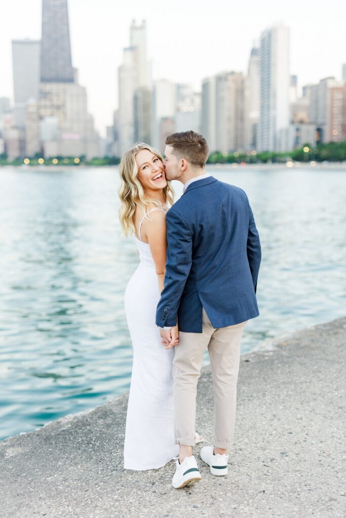 groom kissing brides cheek while she laughs at the camera in chicago illinois