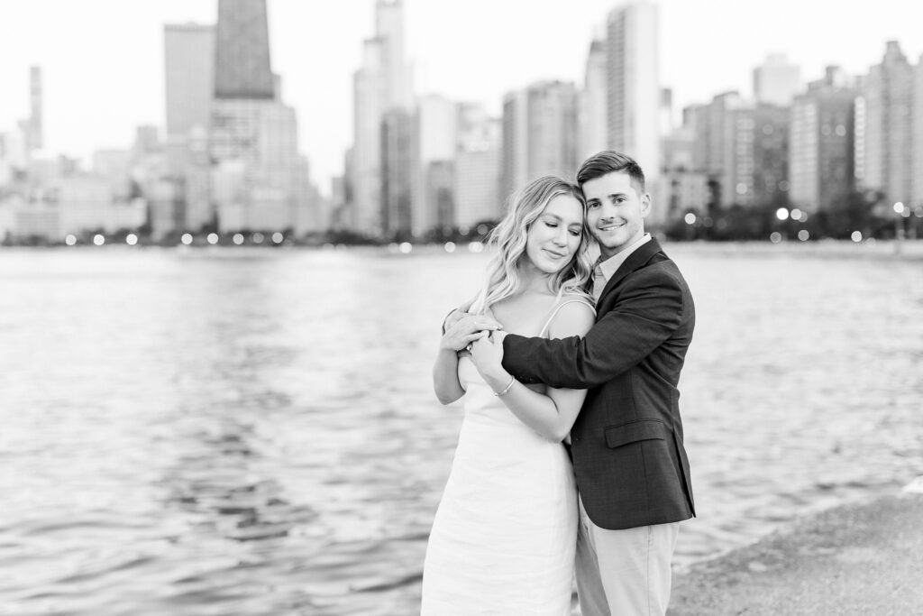 groom holding bride in black and white in front of the skyline 