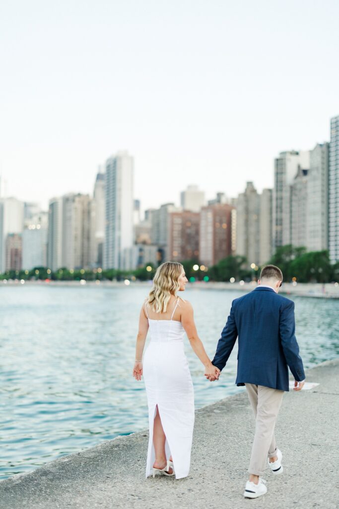 couple walking hand in hand with the chicago skyline in the background