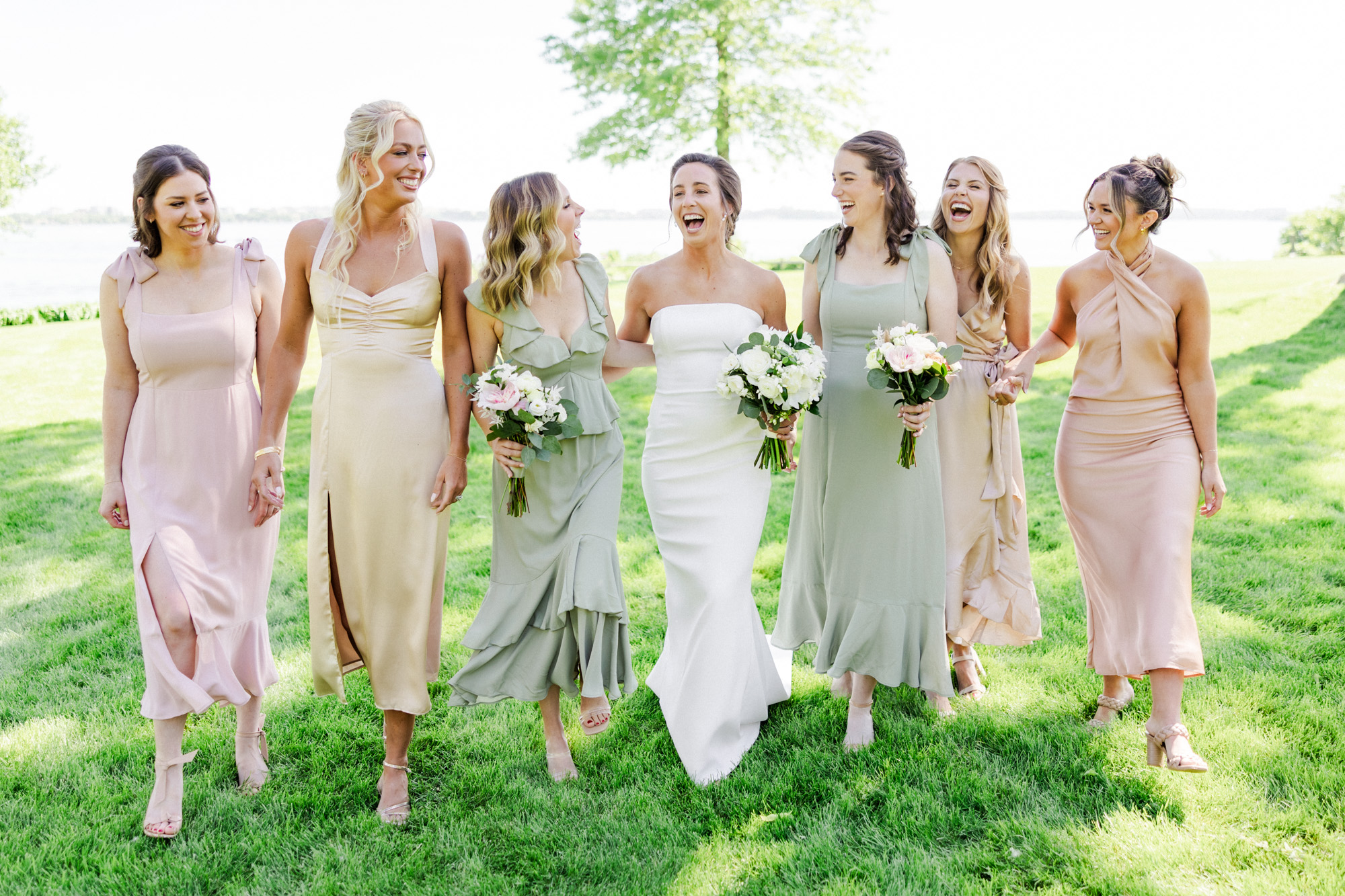 bridesmaids laughing on the lakefront of lake mendota in madison wisconsin