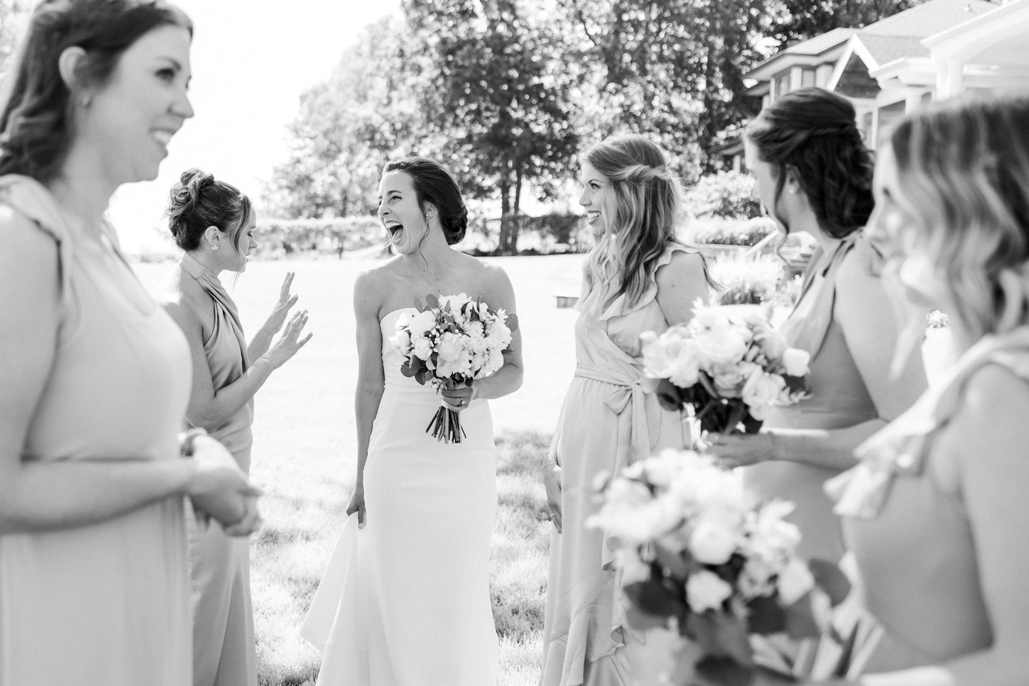 lakefront ceremony bride laughing with her bridesmaids