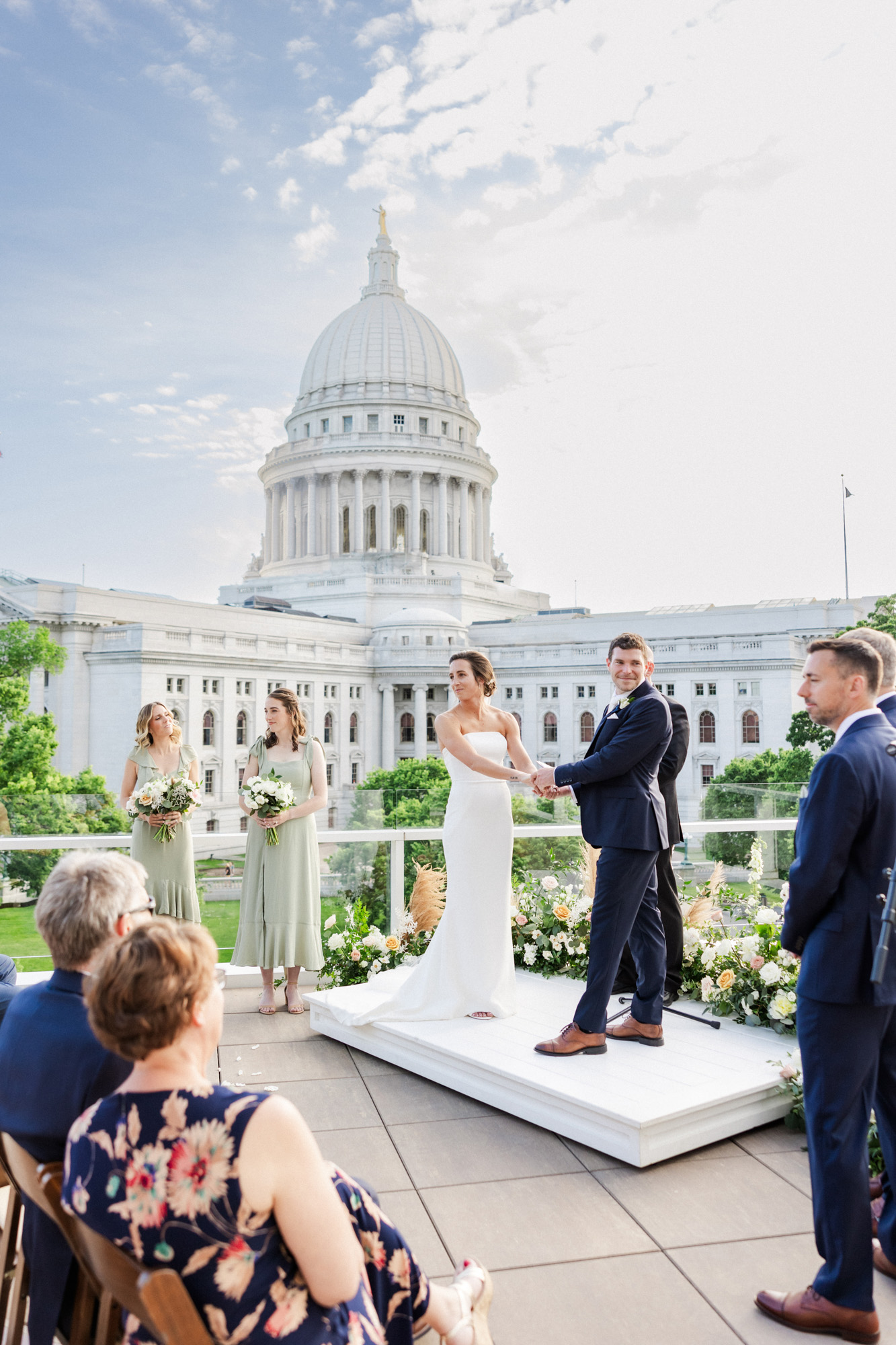 couple looking at their guests during rooftop ceremony with the madison capitol