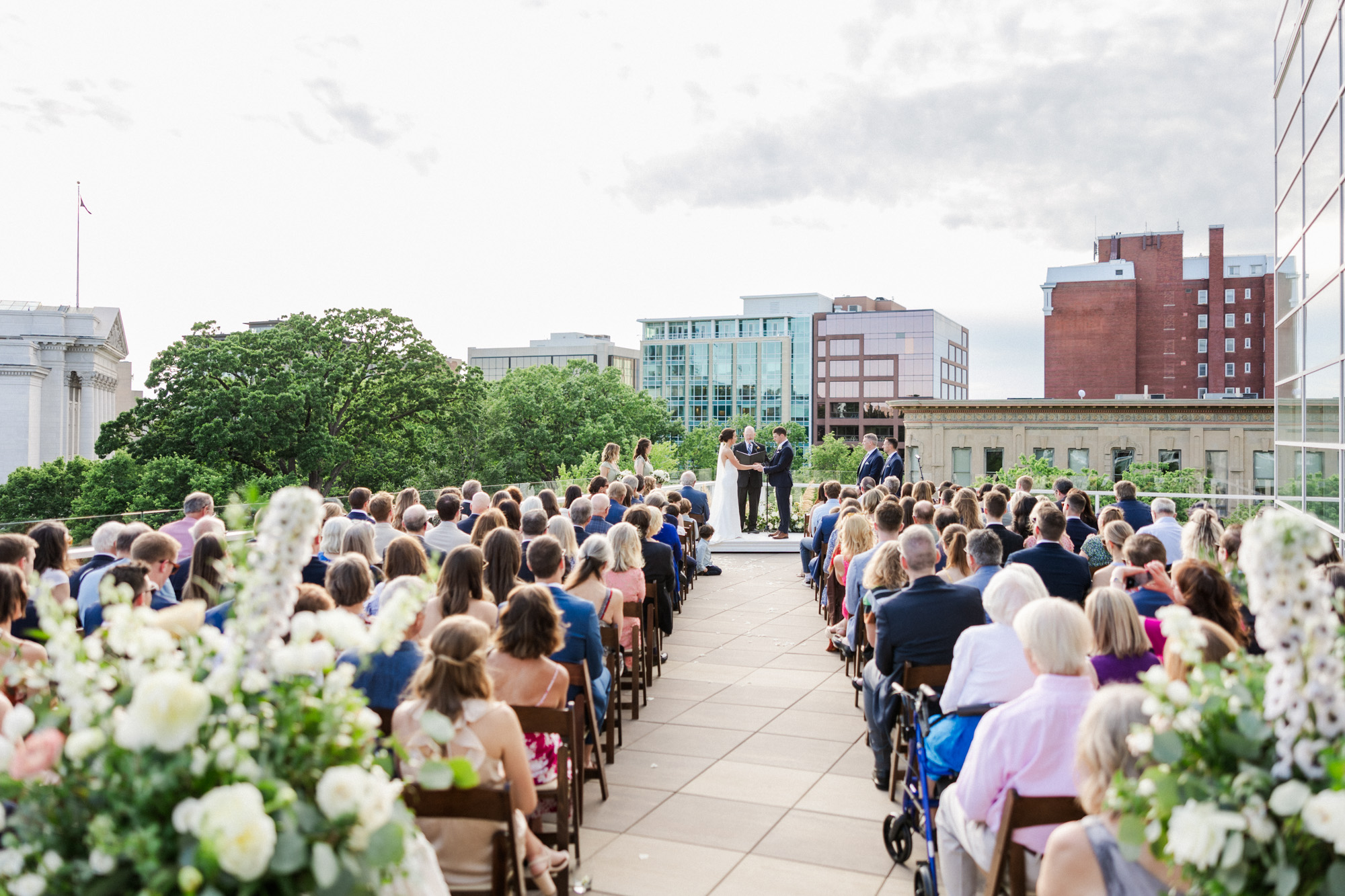 rooftop ceremony with guests watching couple get married