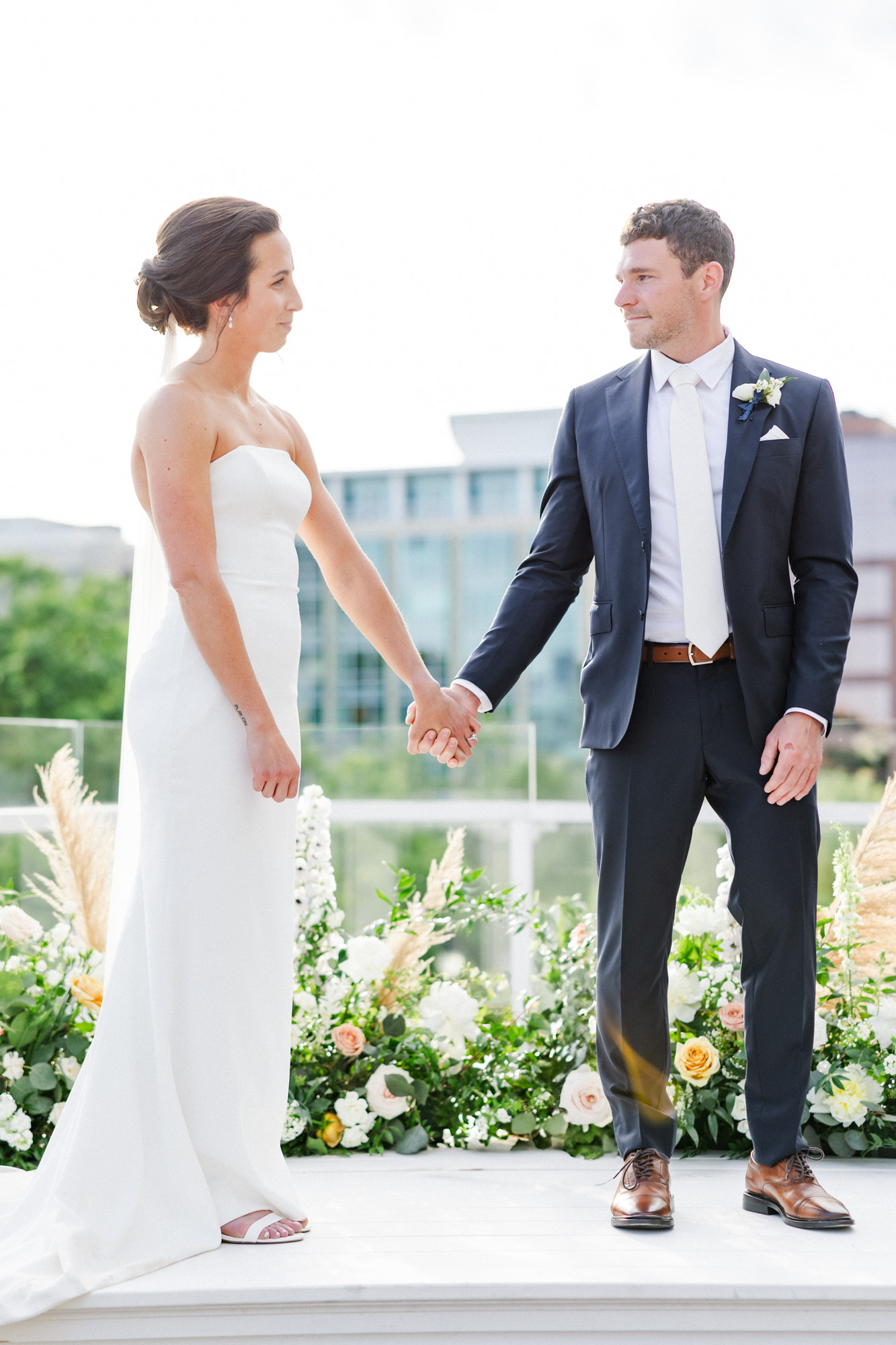 couple holding hands during rooftop ceremony